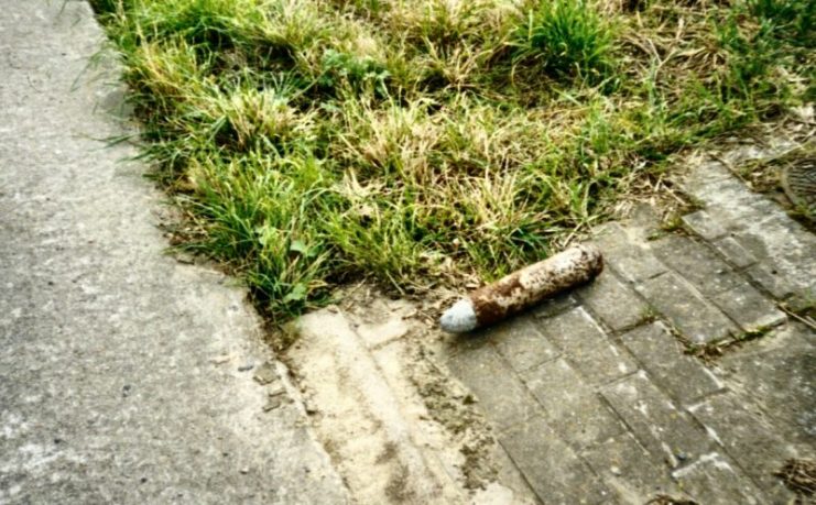 Small German artillery shell from World War I left beside a field for disposal near Ypres, Belgium