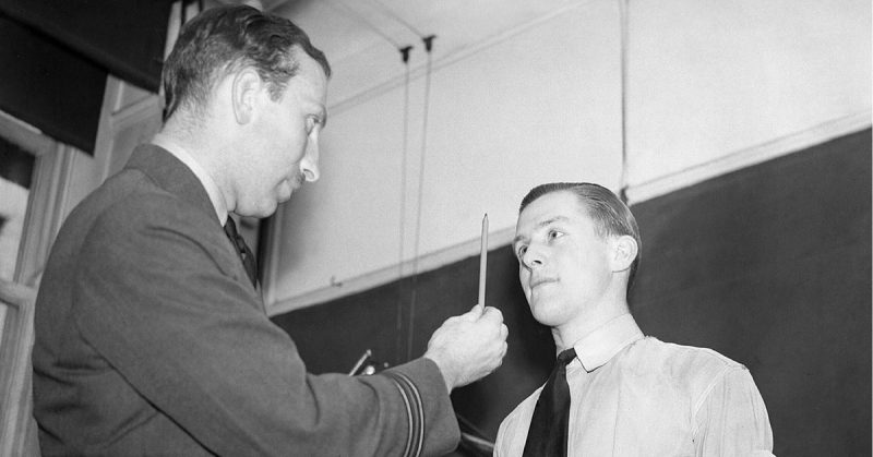 A medical officer conducts an eye test during medical examinations of aircrew candidates