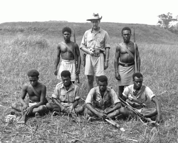 British Solomons Island’s Protectorate district officer and coastwatcher Martin Clemens (center standing) with members of the British Solomon Islands Protectorate Defence Force, who served as scouts and guides for Allied forces throughout the Guadalcanal campaign.