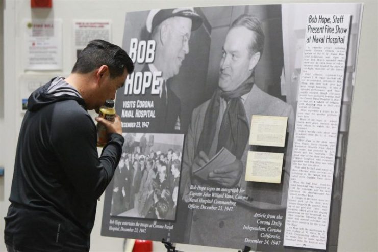 Mark Dasca, Performance Assessment Department engineer, looks at poster board before listening to a recording from a Bob Hope Show performed at Corona Naval Hospital in December 1947 at Naval Surface Warfare Center (NSWC), Corona Division. U.S. Navy photo by Greg Vojtko/Released
