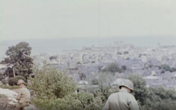 Two soldiers stop for a rest with Cherbourg on the horizon. Public Domain / mediadrumworld.com