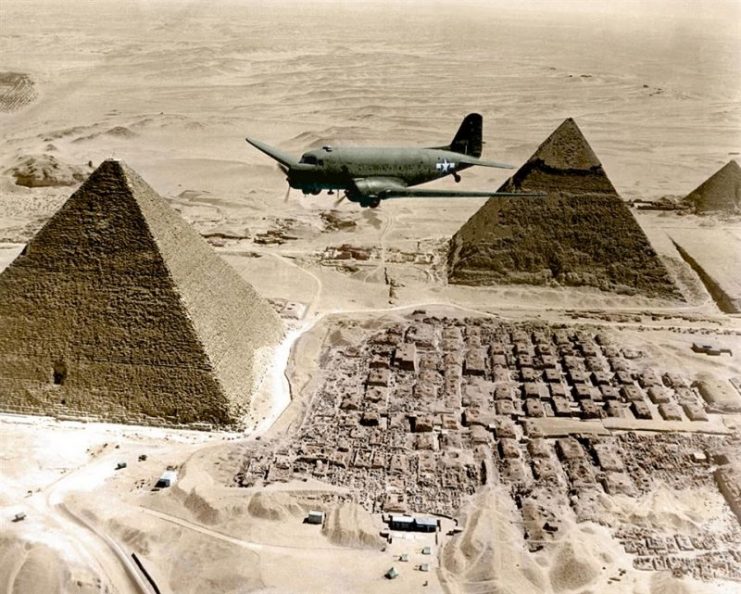 C-47 Skytrain ATC 1944 – An Air Transport Command plane flies over the pyramids in Egypt. Loaded with urgent war supplies and materials, this plane is one of a fleet flying shipments from the U.S. across the Atlantic and the continent of Africa to strategic battle zones. 1943. Paul Reynolds / mediadrumworld.com