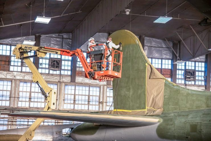 Laying down the olive drab topcoat on the Memphis Belle’s vertical stabilizer. Note the fuselage in the background is the museum’s unique Boeing B-17D model of the Flying Fortress, The Swoose, 40-3097. (U.S. Air Force photo by Ken LaRock)