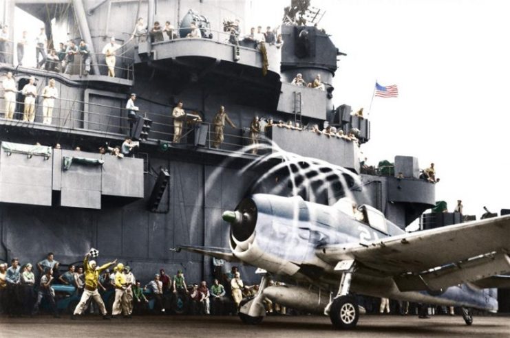 A U.S. Navy Grumman F6F-3 Hellcat fighter makes condensation rings as it awaits the take-off flag aboard USS Yorktown (CV-10), 20 November 1943. The plane is from Fighting Squadron Five (VF-5). Yorktown was then hitting targets in the Marshall Islands to cover the landings in the Gilberts. Paul Reynolds / mediadrumworld.com