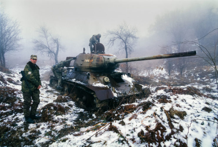 American soldiers deactivating a T-34 while a Russian paratrooper stands nearby