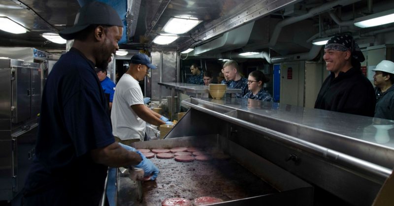 Military Sealift Command civilian service mariner Second Cook Andrew Leggett prepares hamburgers in the galley aboard the submarine tender USS Frank Cable (AS 40). (U.S. Navy photo by Mass Communication Specialist Seaman Heather C. Wamsley)