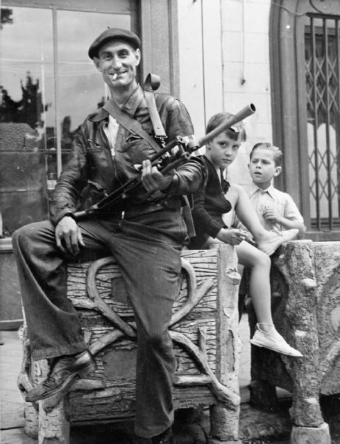 Watched by two small boys, a member of the FFI (French Forces of the Interior), poses with his Bren at Châteaudun, 1944
