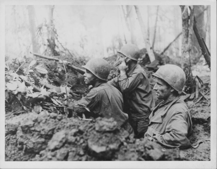 Three American servicemen standing in dense jungle