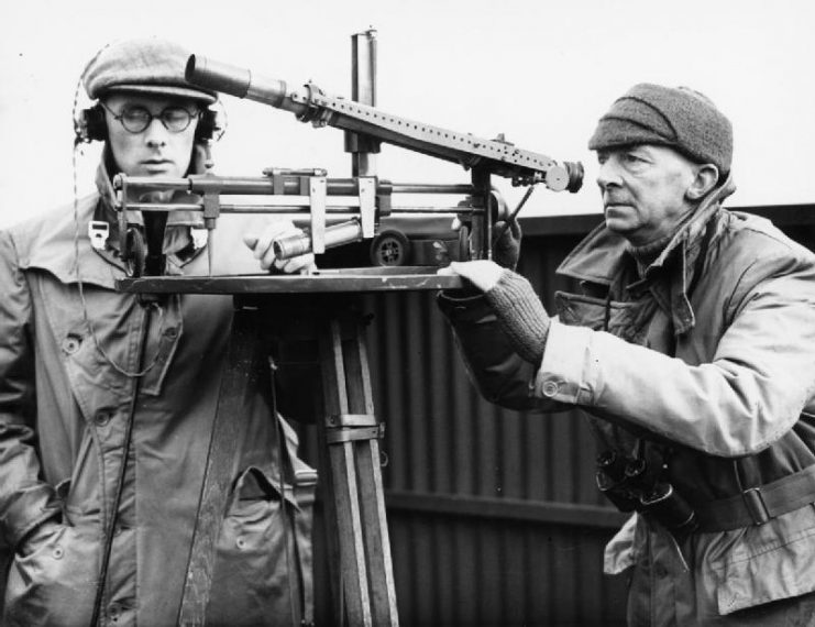 Two members of the Observer Corps chart the movements of aircraft in their sector with a plotting instrument, 29 February 1940.