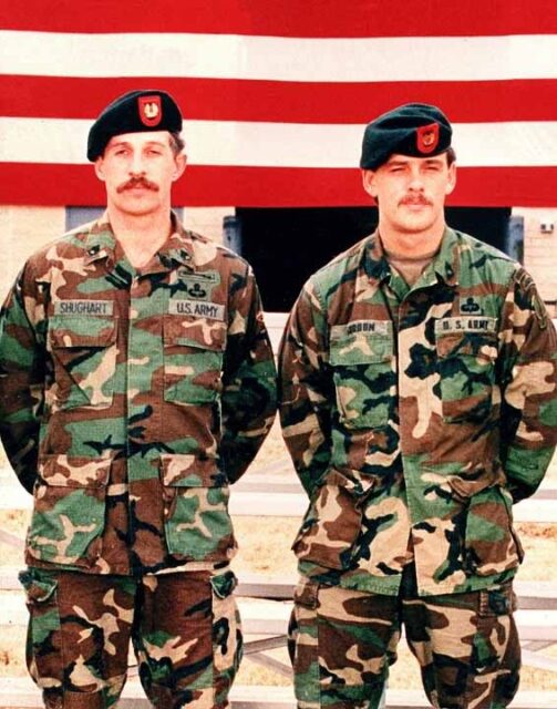 Gary Gordon and Randy Shughart standing in front of the American flag