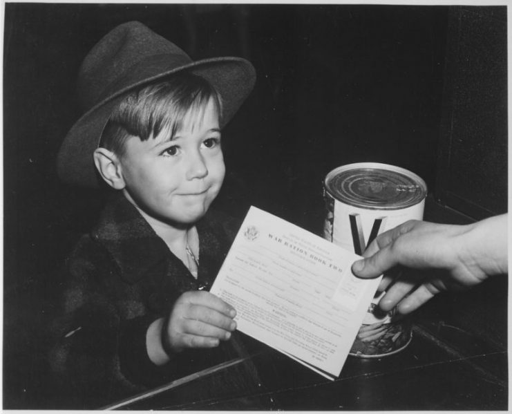 An American child purchases a can of V8 Vegetable Juice, handing the grocer his ration book.