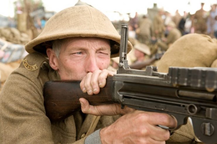 A re-enactor portraying a WWI British soldier manning a Lewis machine gun.