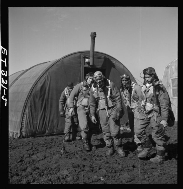 Photograph shows Tuskegee airmen leaving the parachute room, March 1945.