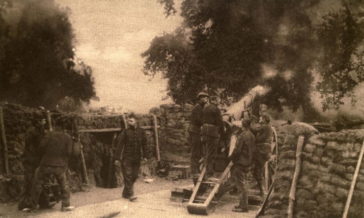 Belgian soldiers standing around artillery pieces