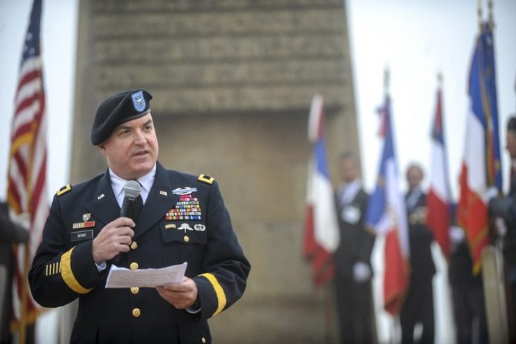U.S. Army Brig. Gen. Blake Ortner, commander of the 29th Infantry Division, speaks during the 29th Infantry Division memorial ceremony at Omaha Beach in Saint-Laurent-sur-Mer, France, June 6, 2016. Liberation Monument (in back) was dedicated to the Soldiers, many of them belonging to the 29th Infantry Division, who stormed the beach and gave their lives to liberate France on D-Day. (U.S. Air Force photo/Staff Sgt. Timothy Moore)
