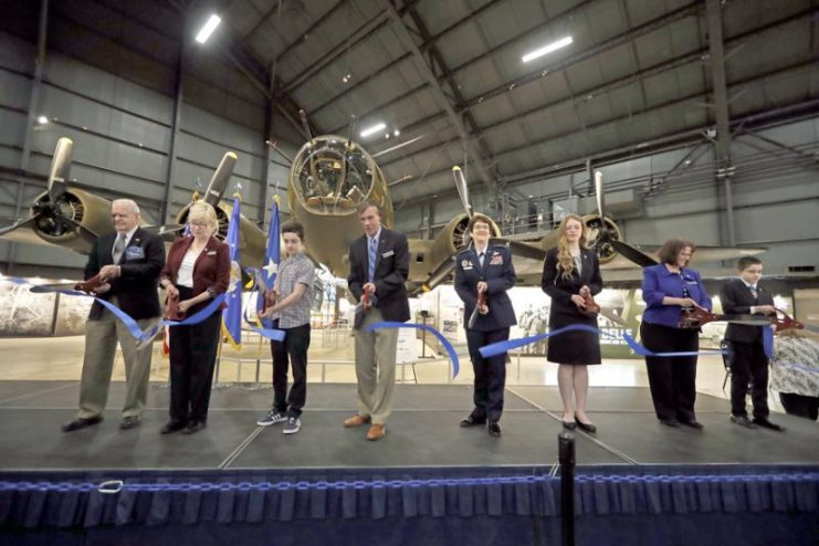 The ribbon is cut to the B-17F Memphis Belle Exhibit during a public ceremony on May 17, 2018. ©U.S. Air Force photo