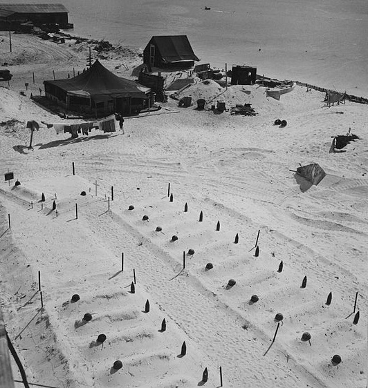 Empty helmets and spent artillery shells mark the graves of Marines who fell at Tarawa, March 1944.