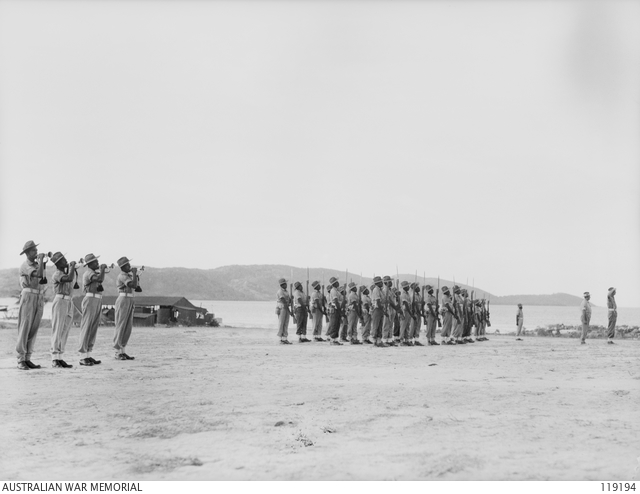 Native troops of the Torres Strait Light Infantry Battalion present arms during the lowering of the colours ceremony. Photo: Lt N. B. Stuckey.