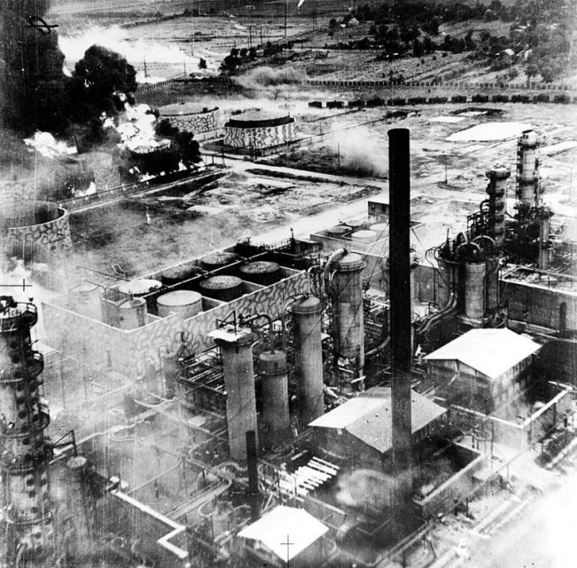 Oil storage tanks at the Columbia Aquila refinery burning after the raid of B-24 Liberator bombers of the United States Army Air Force. Some of the structures have been camouflaged