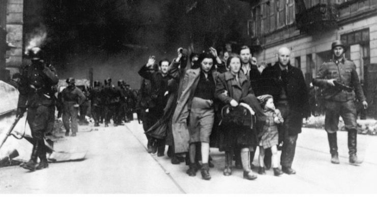 Captured Jews are led by German troops to the assembly point for deportation.