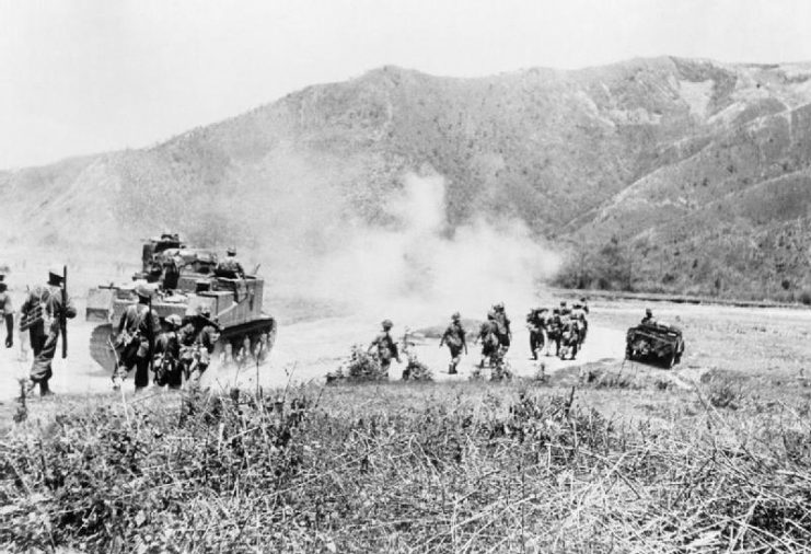 Men of the West Yorkshire Regiment and the 10th Gurkha Rifles advance with the cover of medium M3 Lee-Grant tanks at the Imphal-Kohima road, July 1944.