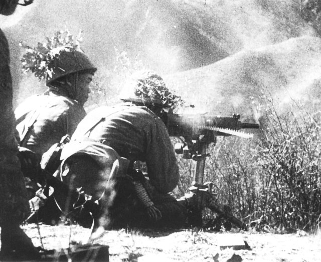 Japanese machine gun crew manning a Type 92 heavy machine gun in action against Commonwealth troops, Eastern Burma, 1945.