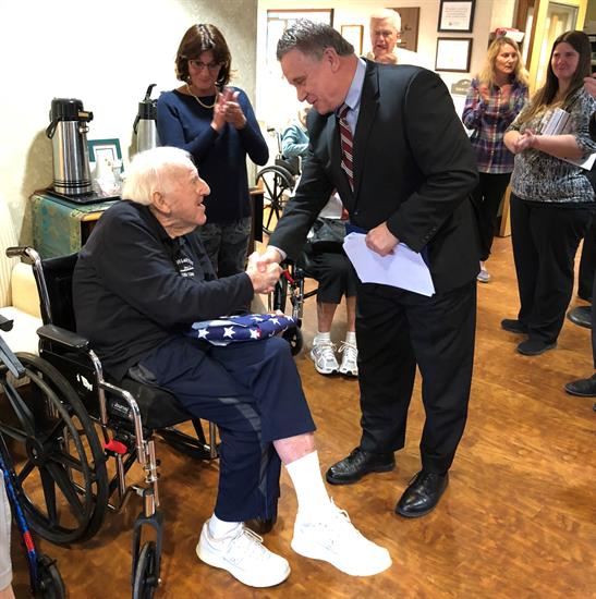 Kelly receiving the folded flag from Congressman Smith.