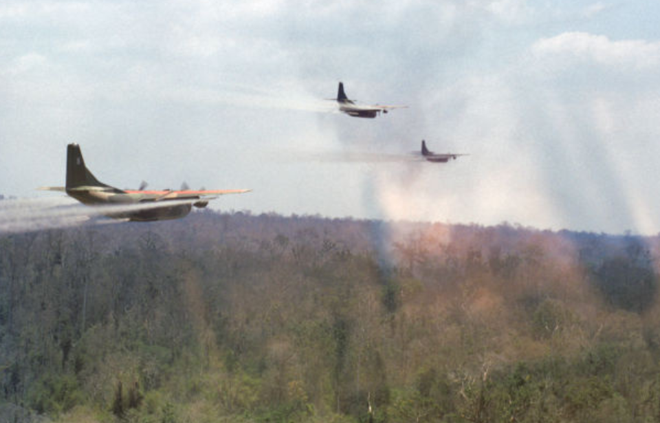 Three Fairchild UC-123B Providers spraying herbicide over a forest