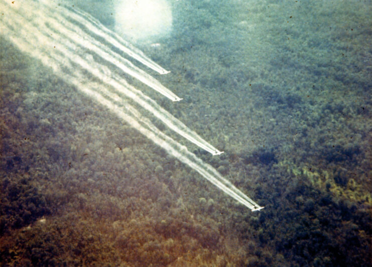 Four Fairchild UC-123B Providers spraying herbicide over a forest