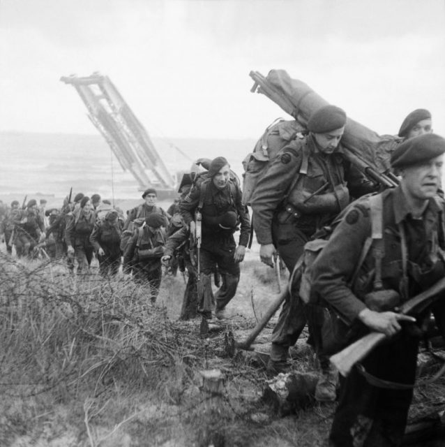 Royal Marine Commandos attached to 3rd Division for the assault on Sword Beach move inland, 6 June 1944. A Churchill bridgelayer can be seen in the background.