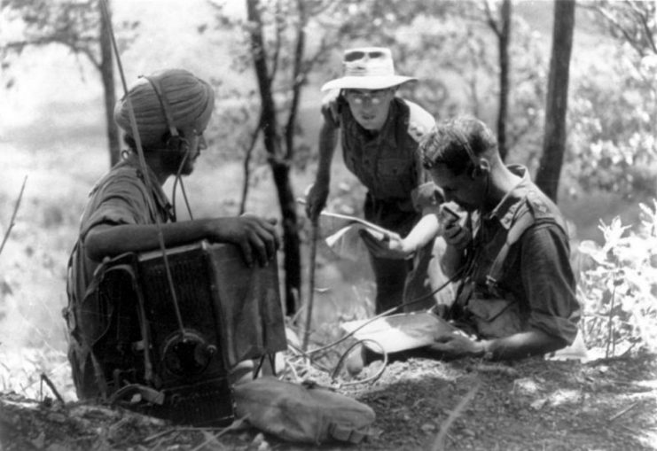 On Imphal front, Sikh signaller operates wireless for British officers, listening to patrols reporting Japanese positions.