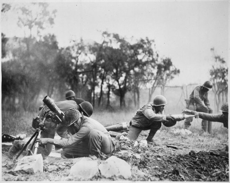 Members of the 92nd Division pass the ammunition and heave it over at the Germans in an almost endless stream near Massa, Italy.