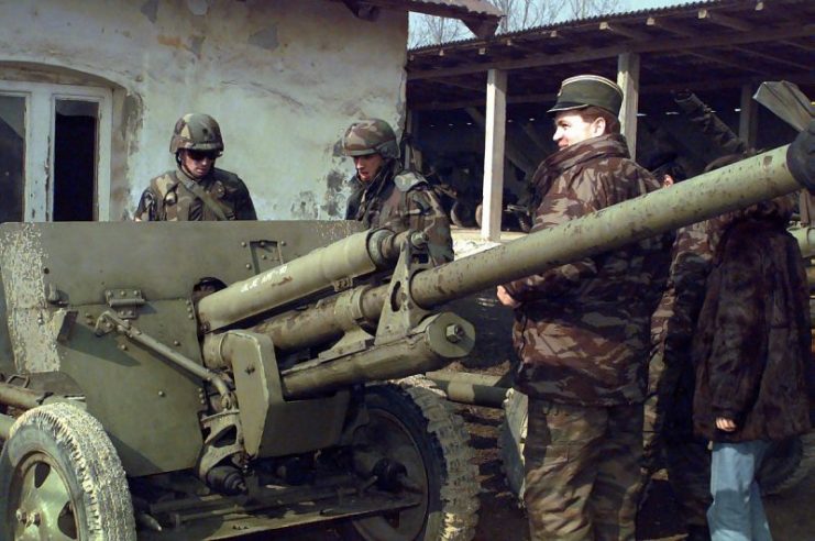 Serbian officer shows U.S. soldiers a towed ZiS-3 anti-tank gun.