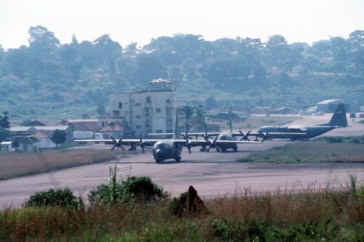Three USAF C-130 Hercules aircraft are parked in front of the empty “Raid on Entebbe” terminal. The building is still pockmarked from the infamous 1976 Israeli rescue operations.