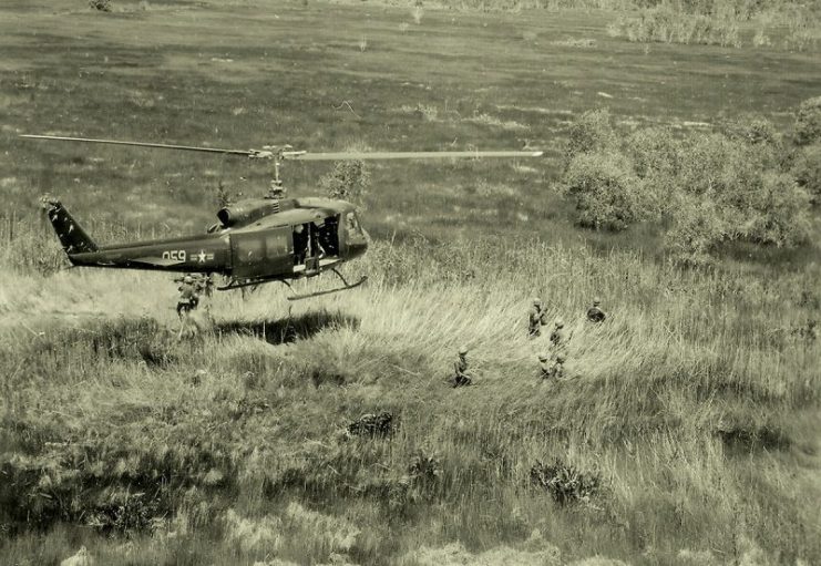 On 18 July 1970, a South Vietnamese Air Force (VNAF) UH-1D Huey helicopter hovers above Vietnamese Air Force personnel of the 211th Helicopter Squadron on a combat assault in the Mekong Delta area of Vietnam.