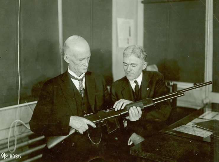 John M. Browning and Mr. Burton studying a BAR at the Winchester Repeating Arms Company plant, Connecticut, United States, circa 1918.