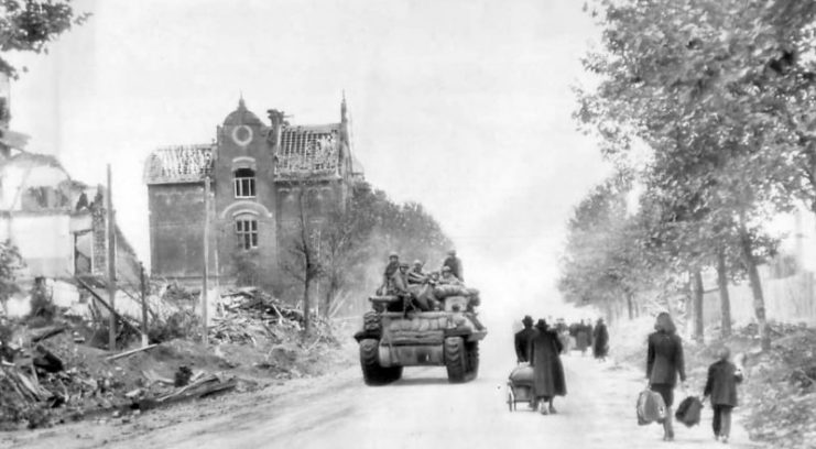 Civilians leave for Allied lines as M10 enters Aachen, 1944