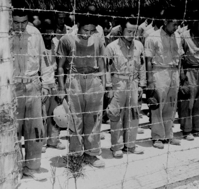 Japanese POW’s at Guam, with bowed heads after hearing Emperor Hirohito make announcement of Japan’s unconditional surrender