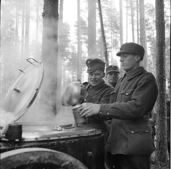 Finnish soldiers gathering breakfast from a field kitchen.