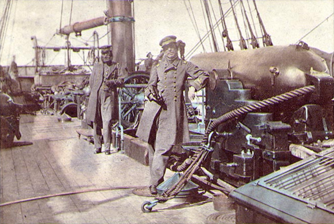 Captain Raphael Semmes, Alabama’s commanding officer, standing aft of the mainsail by his ship’s aft 8-inch smooth bore gun during her visit to Cape Town in August 1863. His executive officer, First Lieutenant John M. Kell, is in the background, standing by the ship’s wheel.