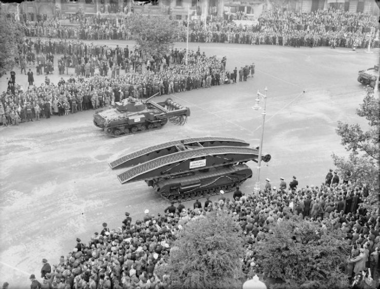 A Churchill bridgelayer in foreground and Sherman Flail (mine clearance vehicle) in background. Part of the Royal Armoured Corps contingent in the Victory Parade in London.