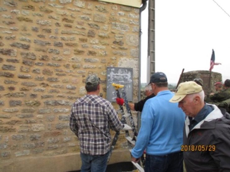 (L-R) Eric Leboeuf, Bill McLaughlin and Paul Clifford, look on as Francis Julien begins to remove the original plaque.