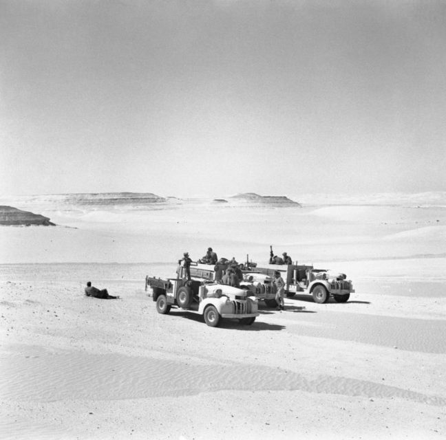 Three Long Range Desert Group 30-cwt Chevrolet trucks, surrounded by desert, 1942.