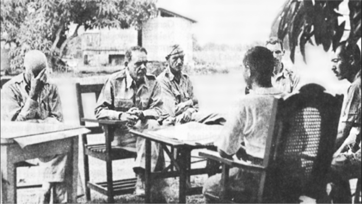 MG Edward King discusses terms of surrender with Japanese officers.