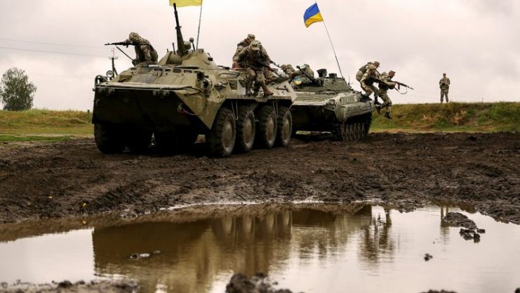 Ukrainian Soldiers of 1st/30th Mechanized Infantry Battalion, role-playing as the opposition force, jump off a BMP-1 and BTR-80 while conducting round robin training during Exercise Rapid Trident 17 at the International Peace Keeping Security Centre in Yavoriv, Ukraine Sept, 12, 2017.