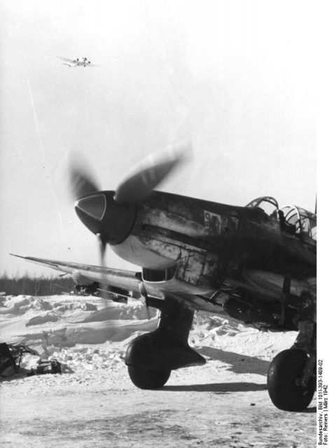German Ju 87D Stuka dive bomber on the ground in Russia, Mar 1942. Note Ju 52 aircraft in flight above. Photo: Bundesarchiv, Bild 101I-393-1409-02 / Reiners / CC-BY-SA 3.0