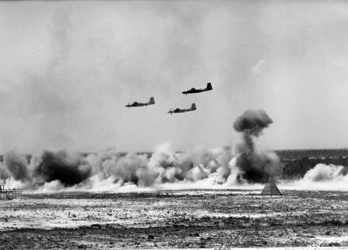 A U.S. Air Force Douglas B-26 Invader bombers at low level strafing and bombing directed at a smoke enveloped tank target during a demonstration.