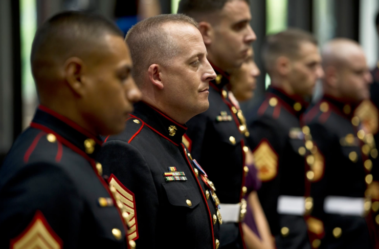 Justin LeHew standing with his fellow Marines