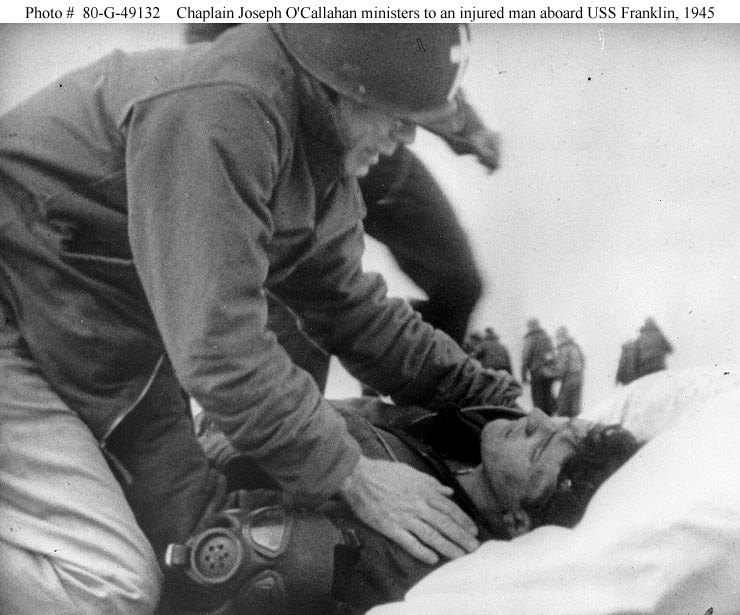Chaplain Joseph O’Callahan ministers to an injured man aboard USS Franklin, 1945.