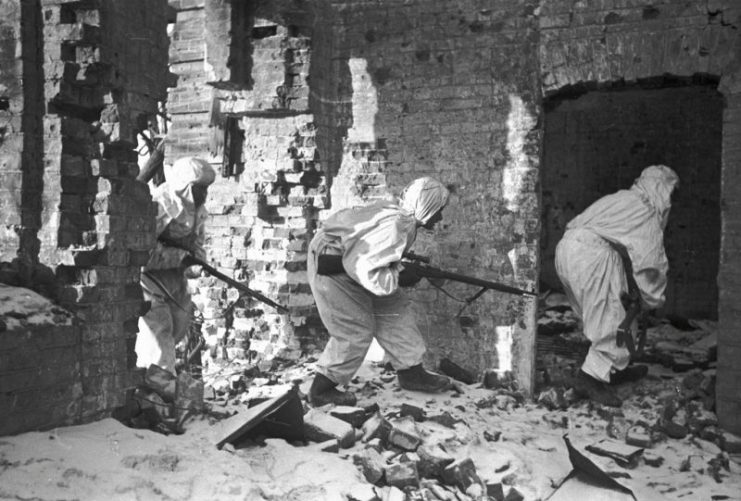 Snipers in camouflage cloaks entering a destroyed house. RIA Novosti / CC BY-SA 3.0